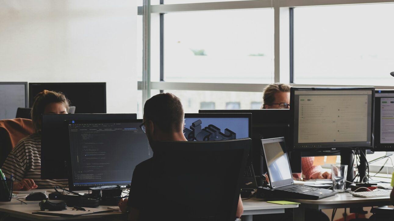 people sitting on chair in front of computer monitor